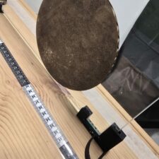 O sistema de avance: cinta métrica e soporte do vidro impreso en 3D coa frecha guía